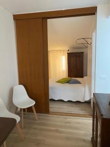 萊里奇的住宿－La Casetta，一间卧室配有一张床和一张白色椅子