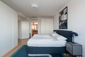 a bedroom with a large white bed with a blue headboard at Luxus über den Wolken, 18. Stock mit Klimaanlage und Garage in Vienna