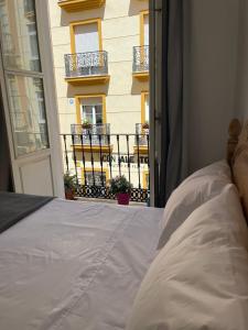 マラガにあるApartamento Ancha del Carmenのベッドルーム1室(ベッド1台付)、窓、バルコニーが備わります。