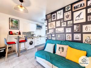 een woonkamer met een blauwe bank en een keuken bij Beauté- Studio-31m2-La Saline Les Bains in La Saline Les hauts 
