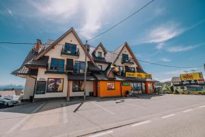 un edificio con techo de gambrel en una calle en Apartamenty u Semlów en Szaflary