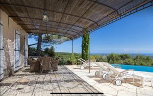 a patio with a table and chairs and a swimming pool at Stramousse in Cabris