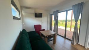 a living room with a green couch and a table and a window at W Kręgu Natury 