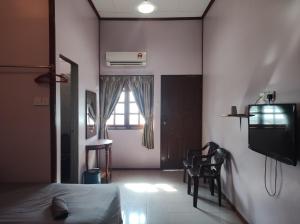a bedroom with a bed and a tv and a window at Horizon Inn in Kampung Teluk Nipah