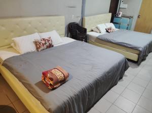 two beds in a room with two beds sidx sidx sidx at Horizon Inn in Kampung Teluk Nipah