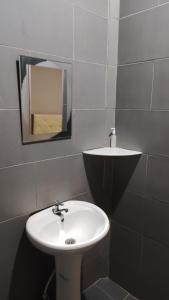 a bathroom with a white sink and a mirror at Horizon Inn in Kampung Teluk Nipah