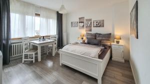 a bedroom with a bed and a table and a desk at Friendly Home - Klinkerhof in Bornheim