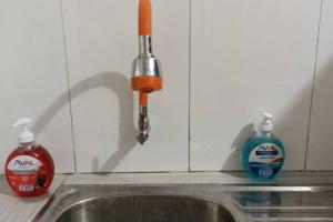 een gootsteen met een kraan en twee flessen reinigingsmiddel bij Vicus 3 habitaciones junin 263 barrio norte Piura in Piura