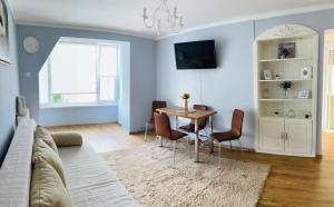 a living room with a table and chairs and a couch at Daniela's rooms in Hunedoara