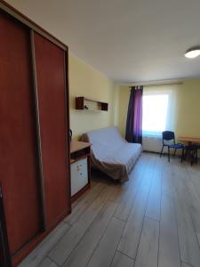 a bedroom with a bed and a desk and a table at Noce i dnie in Białogóra