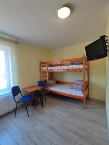 a room with two bunk beds and a table and chairs at Noce i dnie in Białogóra