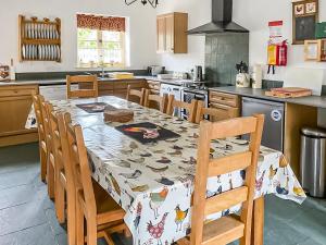 a kitchen with a table and chairs and a kitchen with a stove at Manor Farm Retreat in Hainford