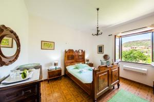 a bedroom with a bed and a sink and a window at La casa di Mannazzotta 1 in Castelsardo