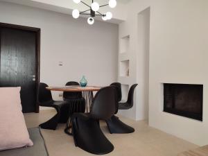 a dining room with black chairs and a table at Stargaze Apartment with Sea View in Zakynthos Town