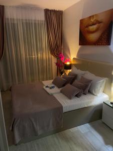 a bedroom with a bed with a picture on the wall at Mamaia Nord - Apartament Beach Resort in Mamaia Sat/Năvodari +31 photos