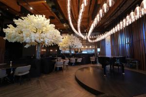 um restaurante com mesas, cadeiras e flores brancas em Dream Island Spa & Health Resort em Sede Yo‘av
