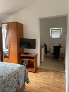 a bedroom with a flat screen tv and a bed at Apartments Manojlovic in Budva