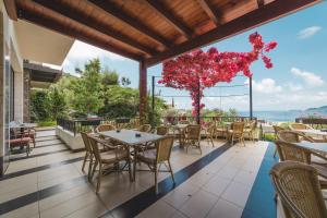 a restaurant with tables and chairs on a balcony at Hotel & Apartments HEC Residence in Sveti Stefan