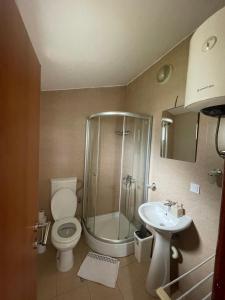 a bathroom with a shower and a toilet and a sink at Apartments Manojlovic in Budva