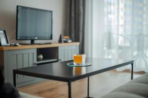 ein Glas Orangensaft auf einem Tisch im Wohnzimmer in der Unterkunft GAVAS APARTMENTS VIVA City in Cluj-Napoca