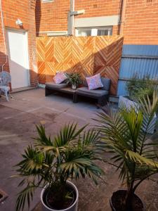 a patio with a couch and some plants and a fence at Dreamhouse in Melbourne