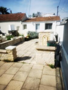 a patio in front of a white house at petite maison 15 mn à pied du marche et vieux port in La Rochelle