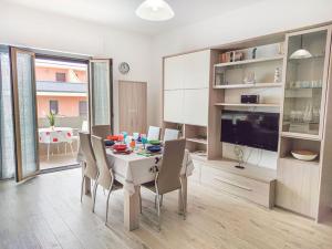 une salle à manger avec une table, des chaises et une télévision dans l'établissement Appartamento Alighieri primissima fila mare, à Martinsicuro