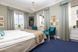 a bedroom with a bed and two blue chairs at Lady Hamilton Hotel in Stockholm +96 photos