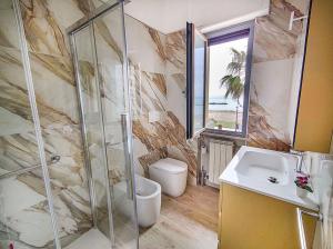La salle de bains est pourvue d'une douche et d'un lavabo. dans l'établissement Appartamento Alighieri primissima fila mare, à Martinsicuro