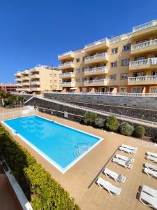 una piscina frente a un edificio en Tropical Apartment - Heated Pool en El Palmar