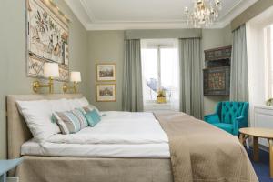 a bedroom with a large bed with a blue chair at Lady Hamilton Hotel in Stockholm