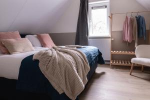 une chambre avec un lit, une fenêtre et une chaise dans l'établissement Luxe Vakantiehuis Ruwe Iep Veluwe, à Nunspeet