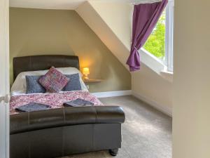 1 dormitorio con cama y ventana en The Grooms Cottage, en Mauchline
