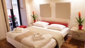 Dos camas en una habitación con toallas. en Micalò Art Rooms en Nápoles