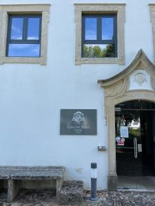 un edificio con una puerta y un banco delante de él en Casa do Adro Hotel, en Ferreira do Zêzere