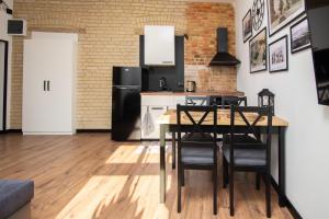 a kitchen with a table and a black refrigerator at Portowa 11 Gdynia in Gdynia