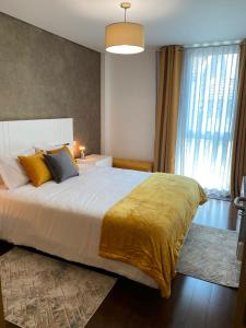 1 dormitorio con 1 cama grande con manta amarilla en Host'In Aveiro Arrais, en Aveiro