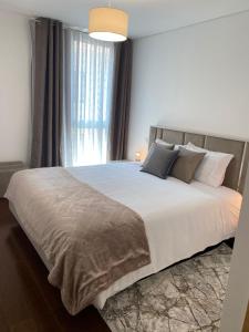1 dormitorio con 1 cama grande y ventana grande en Host'In Aveiro Arrais, en Aveiro