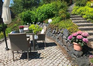 a patio with a table and chairs and flowers at Exklusives Ferienhaus Conradshöh mit Sauna und Terrasse in Ilmenau