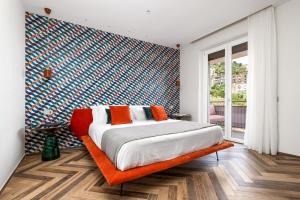 een slaapkamer met een groot bed en een oranje bank bij FUTURA SMART Flat Sorrento in Sorrento
