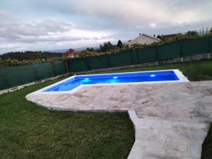 a swimming pool with blue lighting in a yard at villa requian in Cacheiras
