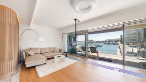 sala de estar con sofá y ventana grande en Flatbook - City Center Apartments Yacht Park, en Gdynia