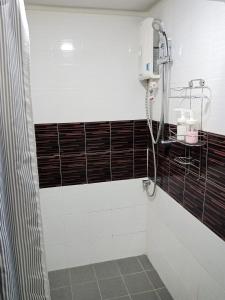 y baño con ducha y azulejos blancos y negros. en Nesto Condo at Muangthong en Pak Kret