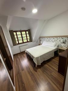 a bedroom with a large bed and a window at Hello Astur Green in Bimenes