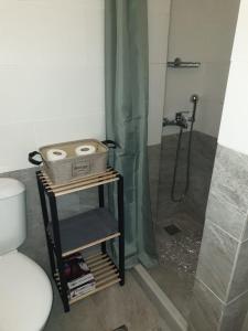 a bathroom with a shower with a basket on a shelf at ēnNĒ Studios for Views & Tranquility in Ftelia