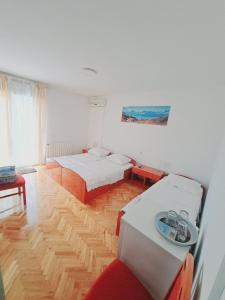 Sala de estar con 2 camas y mesa en Guesthouse Varnica, en Kaštela