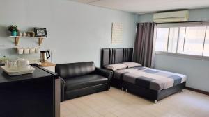 1 dormitorio con 1 cama y 1 silla en Nesto Condo at Muangthong, en Pak Kret