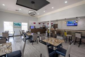 restauracja ze stołami i krzesłami oraz bar w obiekcie Best Western Plus Lafayette Vermilion River Inn & Suites w mieście Lafayette