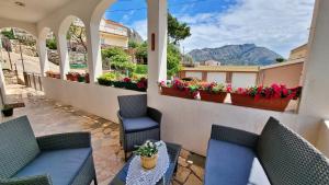 a patio with two chairs and a table and flowers at Apartment Gogo Duce in Duće