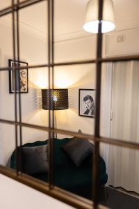 a mirror reflecting a room with a couch and a lamp at Trendy 2Bed flat Bethnal Green in London